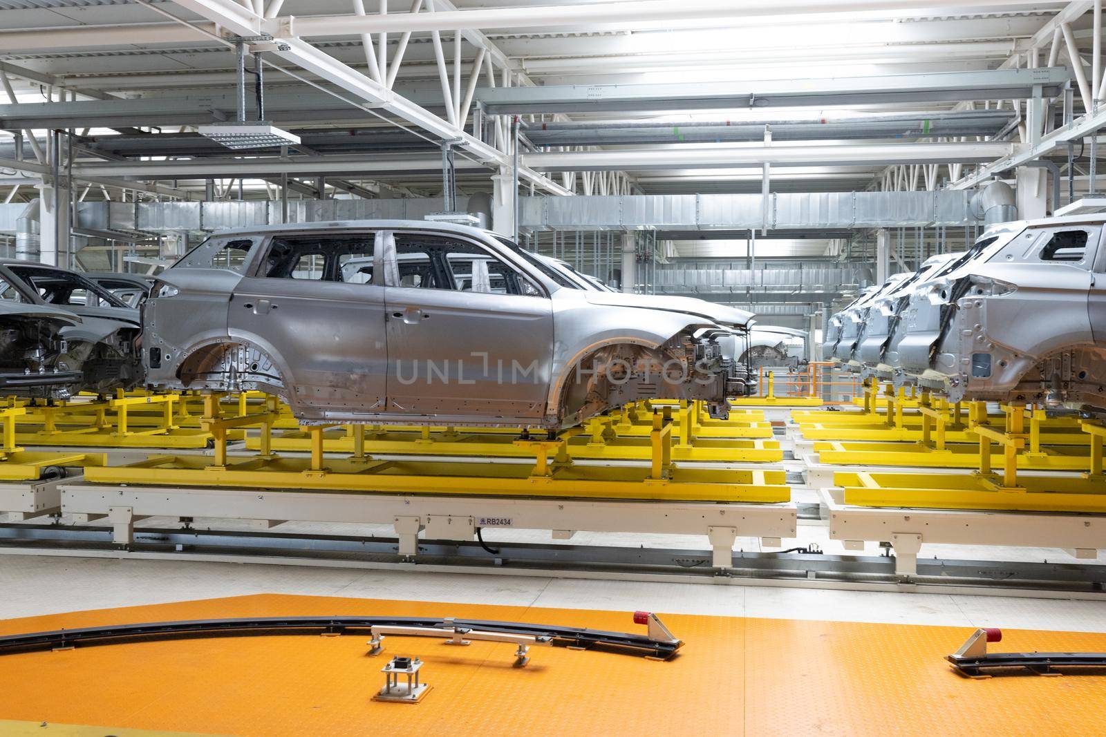 Car bodies are on assembly line. Factory for production of cars. Modern automotive industry.