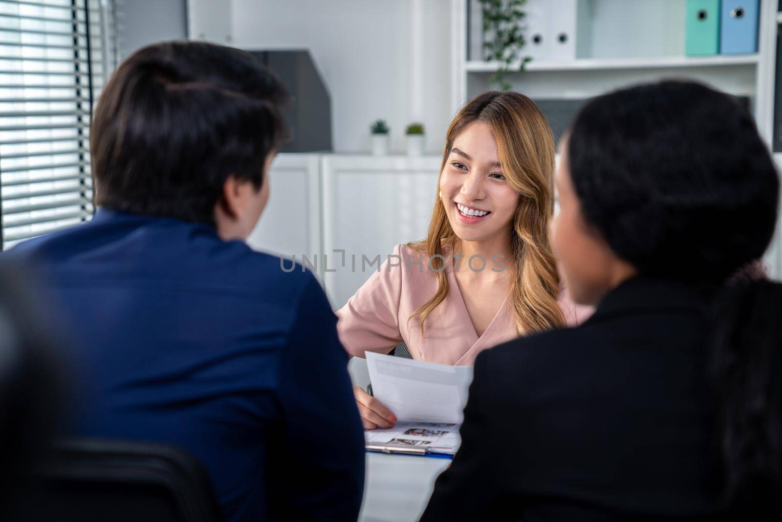 A young female asian candidate tries to impress her interviewer by being competent. International company, multicultural environment in workplace.