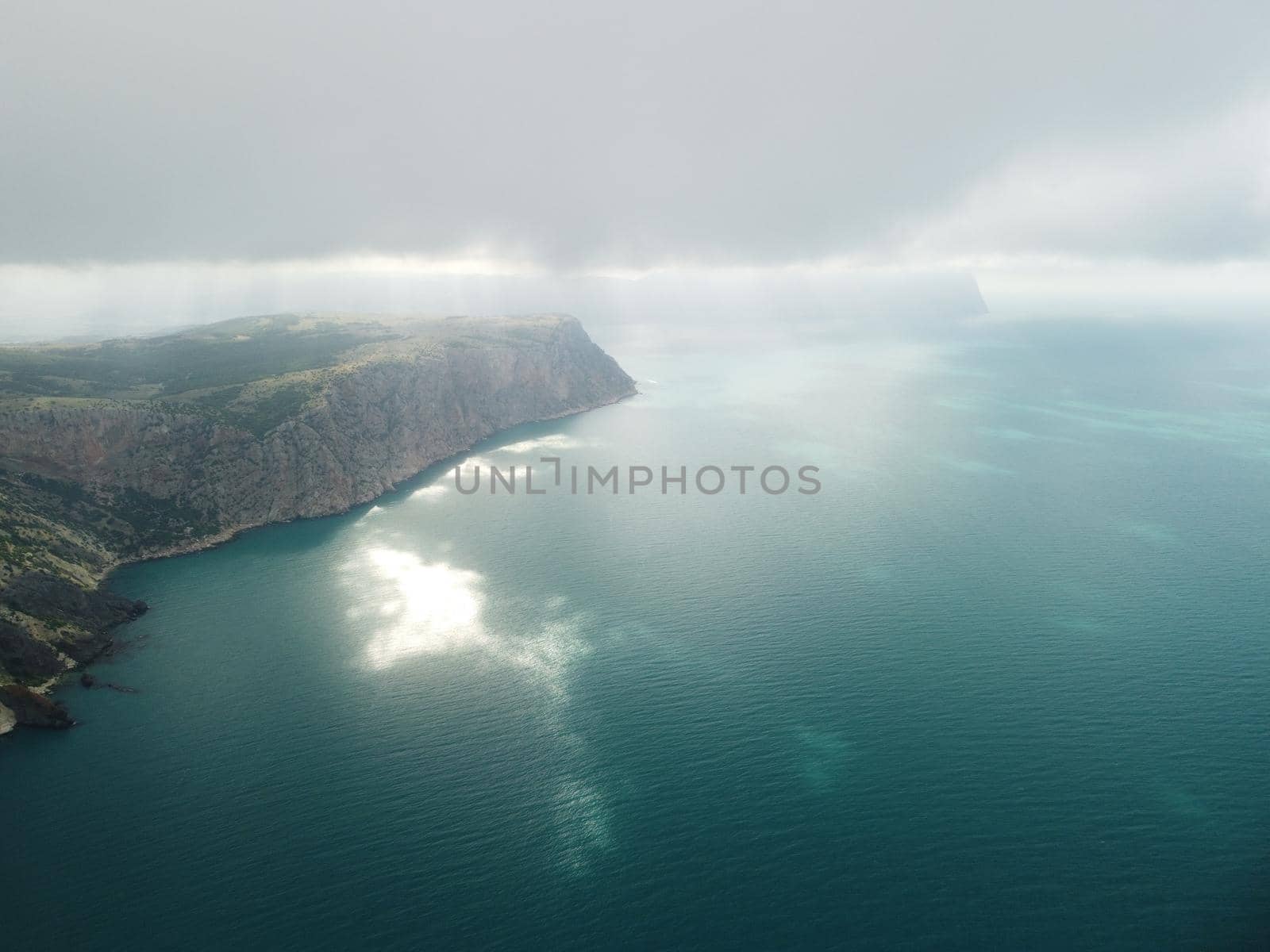 Aerial view from above on calm azure sea and volcanic rocky shores. Small waves on water surface in motion blur. Nature summer ocean sea beach background. Nobody. Holiday, vacation and travel concept by panophotograph