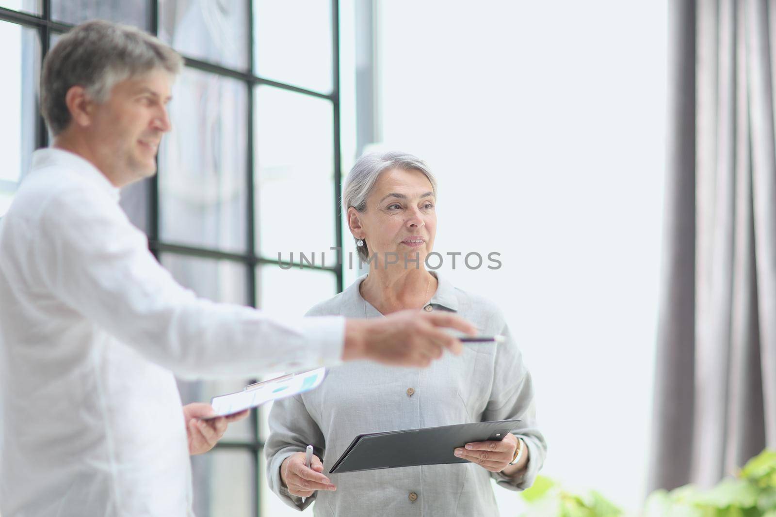 businessman showing something to mature businesswoman seen throu by Prosto