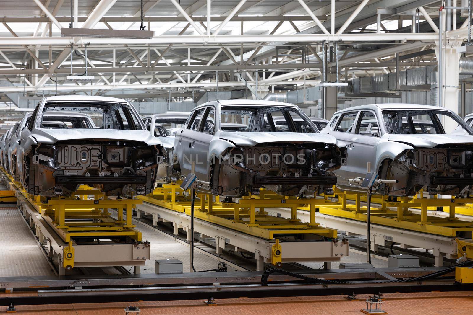 Photo of automobile production line. Welding car body. Modern car assembly plant. Auto industry. Interior of a high-tech factory.