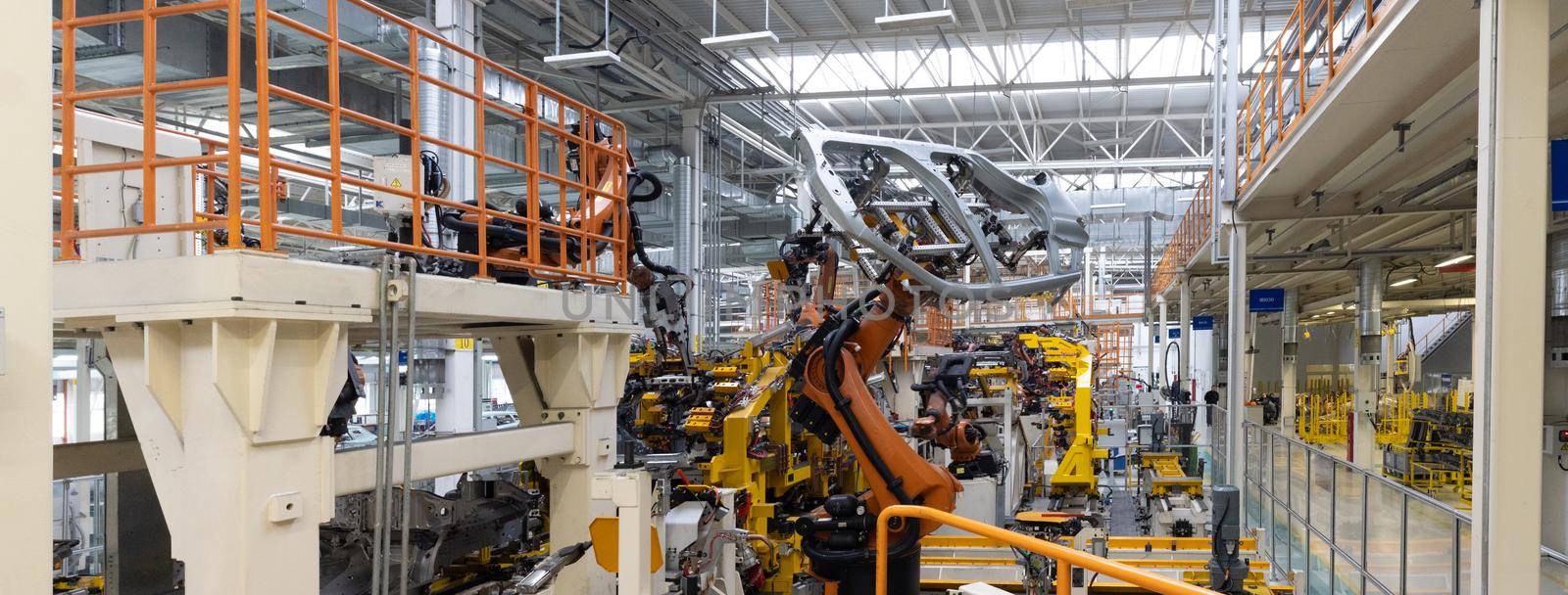 Panoramic photo of automobile production line. Welding car body. Modern car assembly plant. Auto industry.