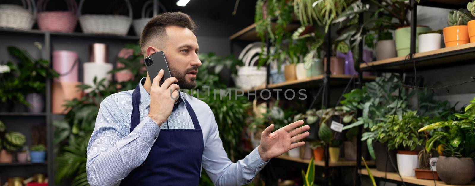 flower warehouse worker at a garden center answering a phone call.