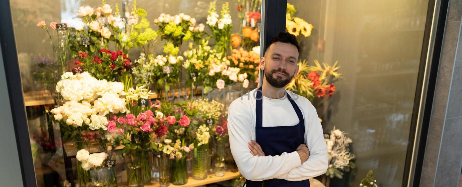 the owner of the flower shop next to the refrigerator with beautiful bouquets.