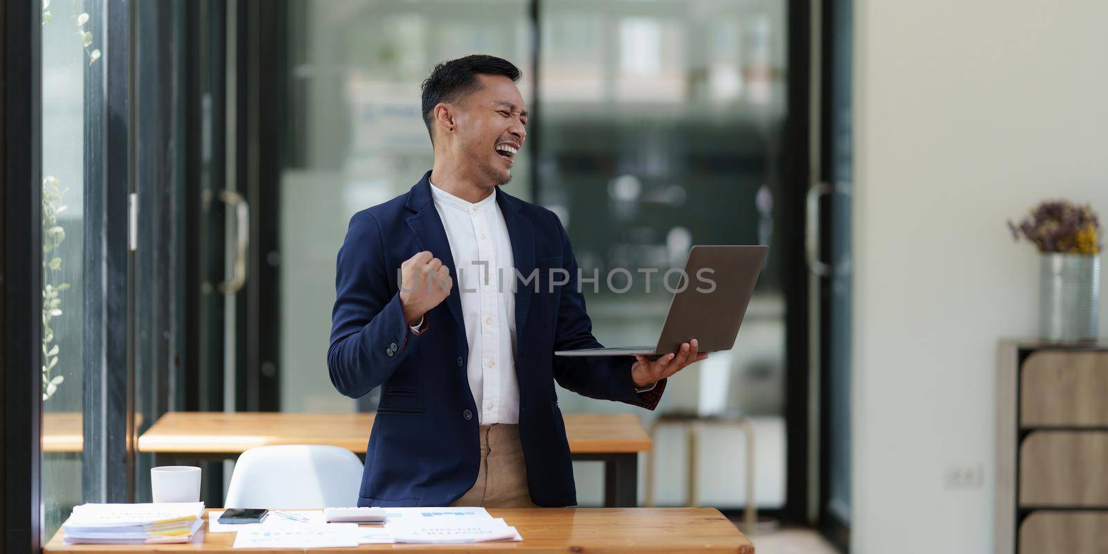 A successful entrepreneur analyzing a technical price graph and indicator with laptop computer.