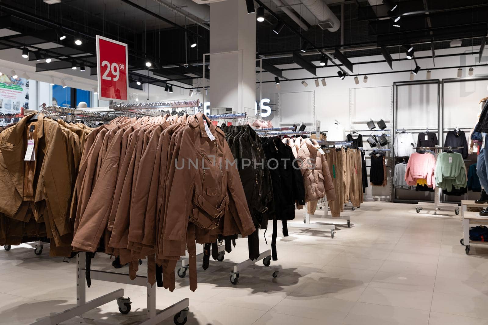 interior of a store selling stylish inexpensive clothes, jackets on hangers in a wide range.