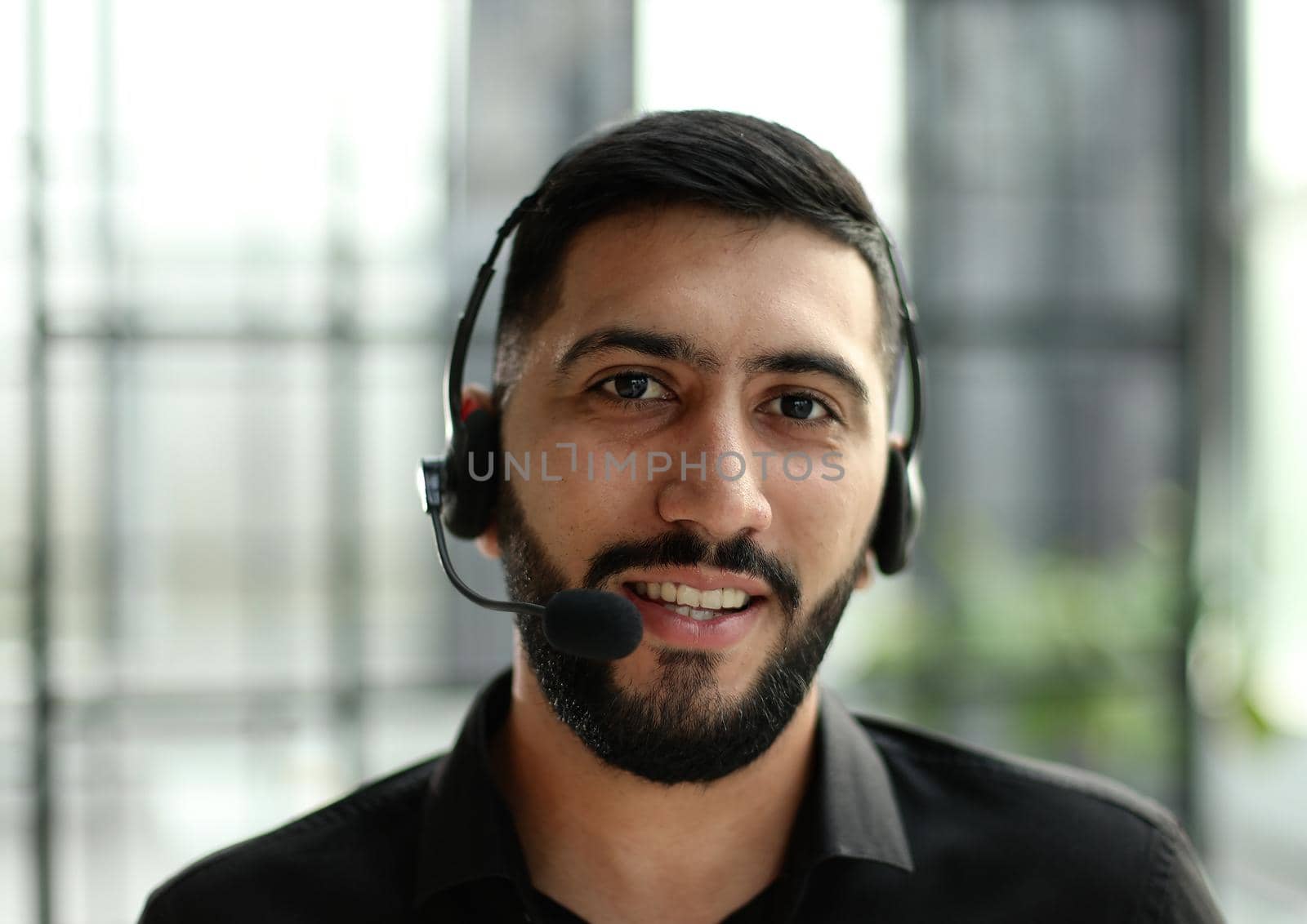 Portrait of an attractive businessman working in a call center by Prosto