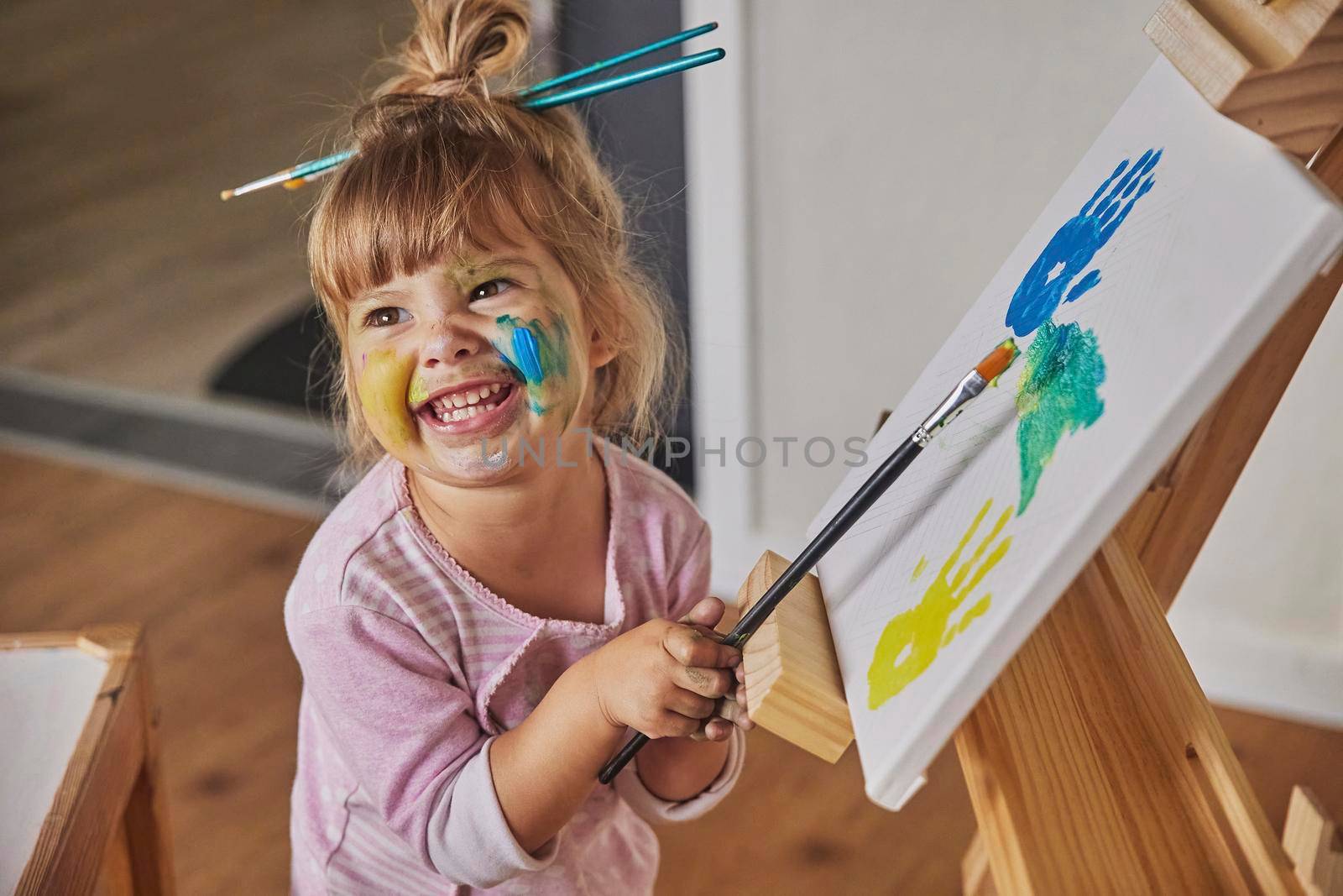 Charming child draws and stains everything with paints.