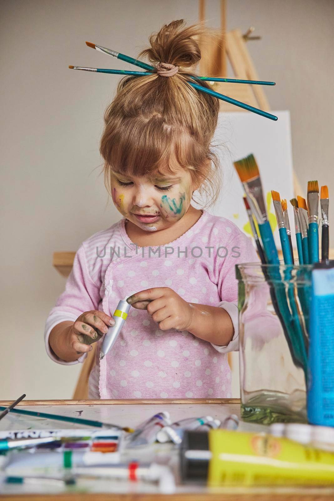 Charming child draws and stains everything with paints.