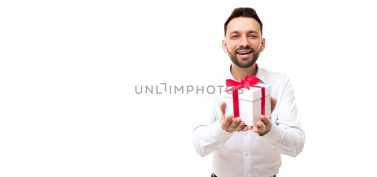 a man in a white shirt presents a box with a gift pulling it forward