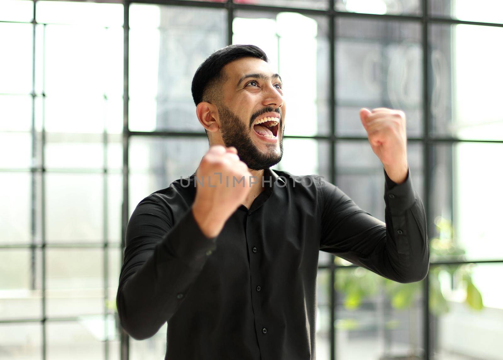 young businessman celebrating success in his home office by Prosto