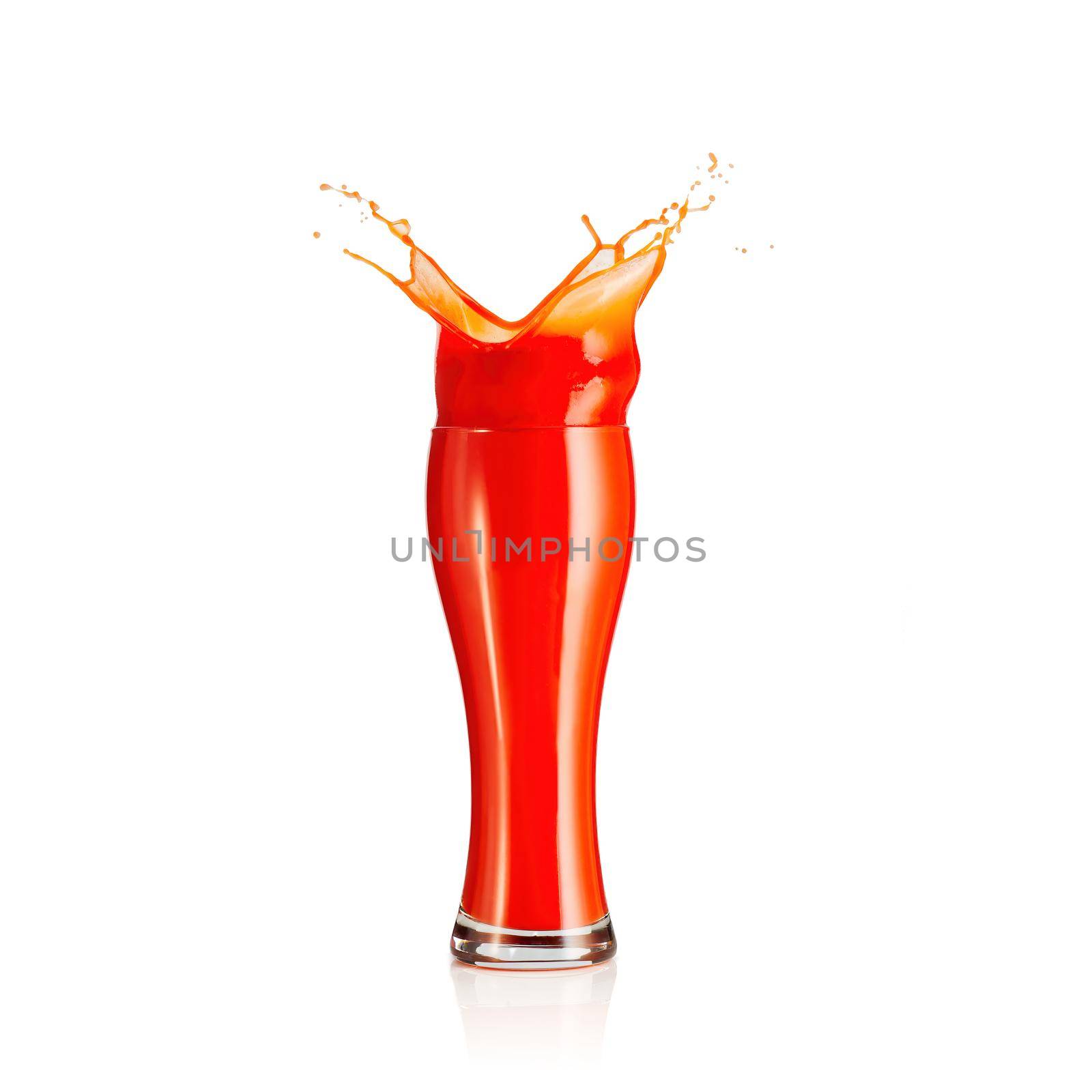 splash of tomato juice isolated on white background. juice in beer glass splashing