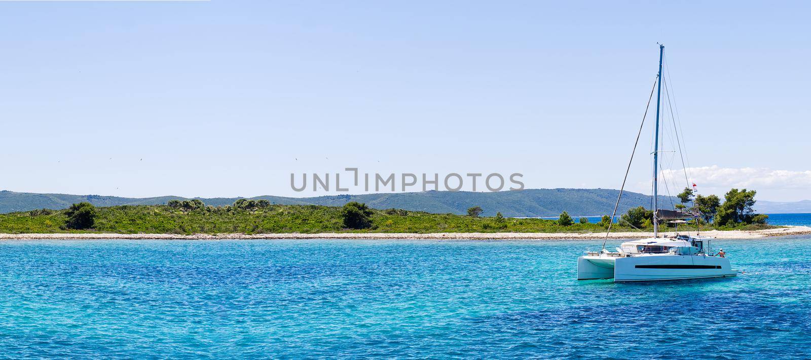 catamaran sailing in ocean. paradice at sea. Blue sky and turquoise blue sea water. by PhotoTime