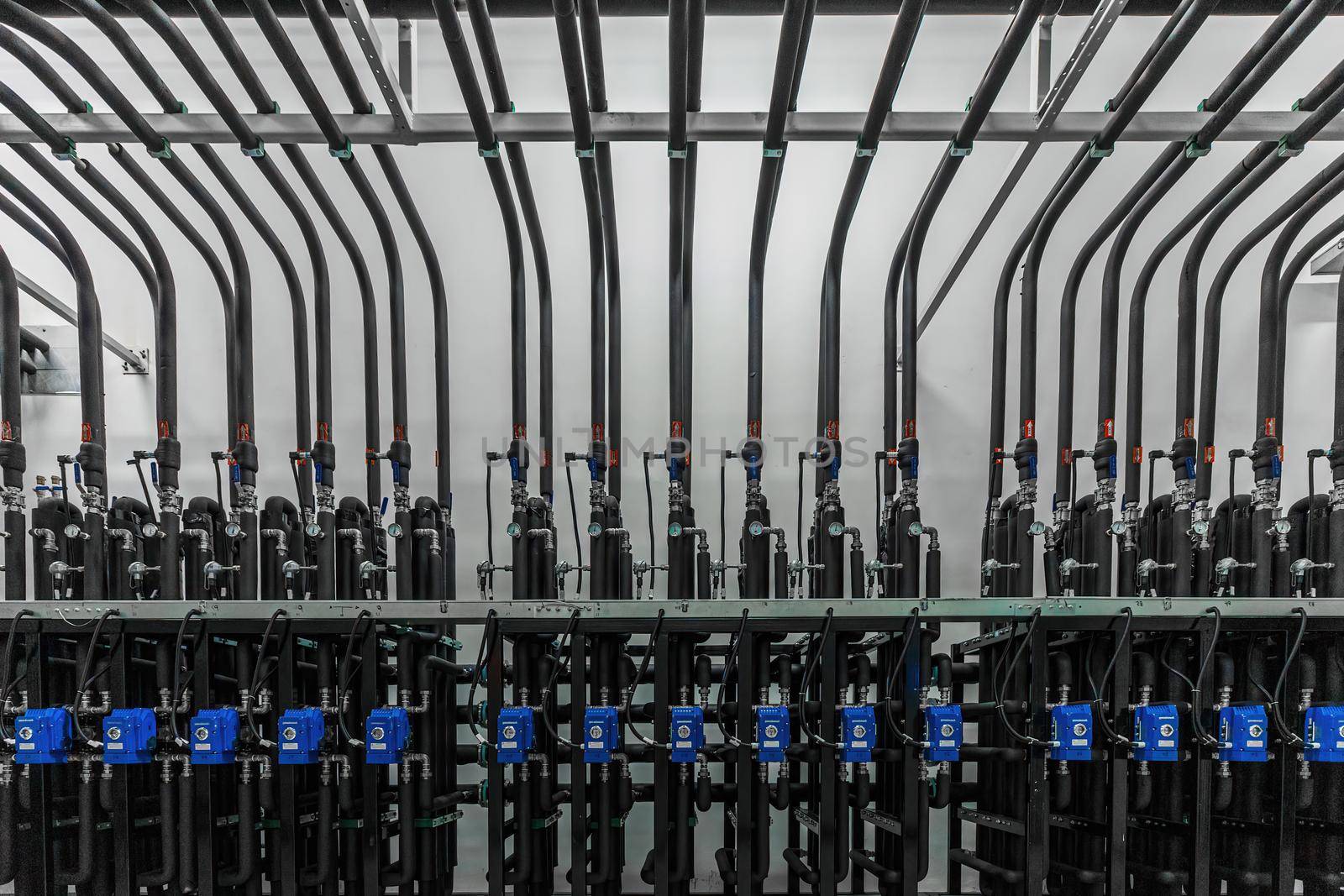 Photo of production pumps on the wall in a modern factory. Chemistry and medicine production. Pharmaceutical high-tech plant interior.