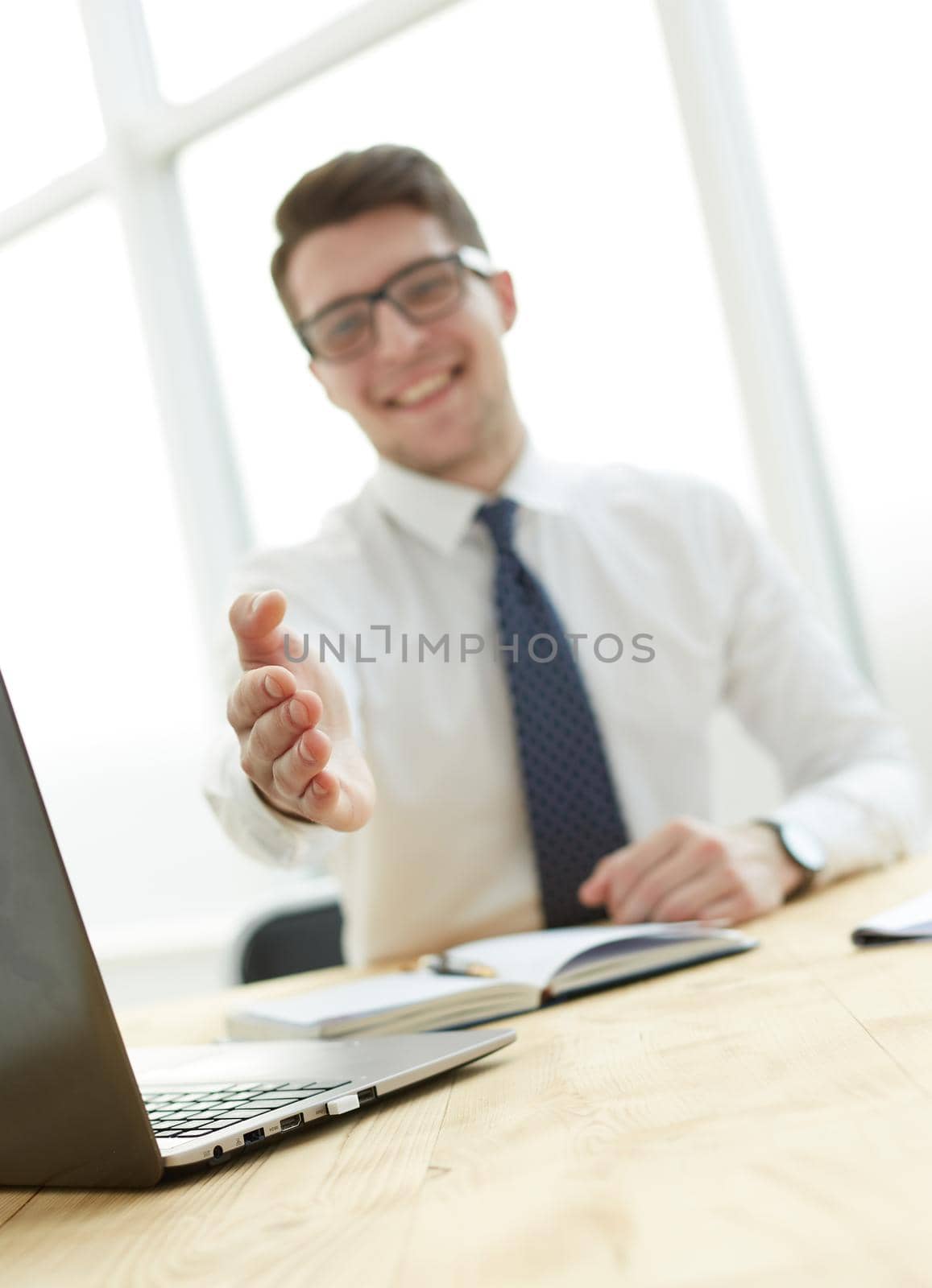 Businessman extending hand to shake at light modern office by Prosto