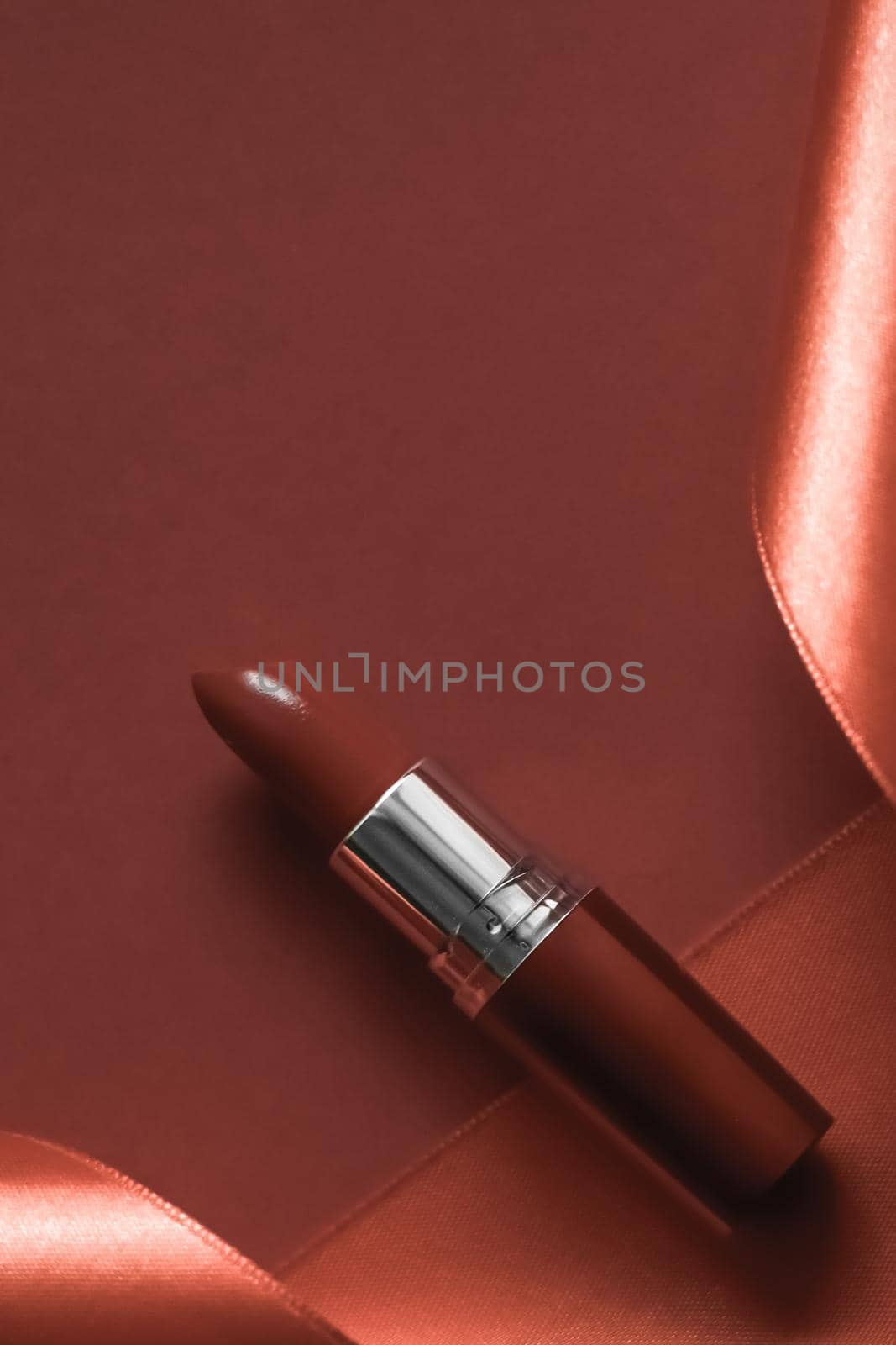 Cosmetic branding, glamour lip gloss and shopping sale concept - Luxury lipstick and silk ribbon on bronze holiday background, make-up and cosmetics flatlay for beauty brand product design