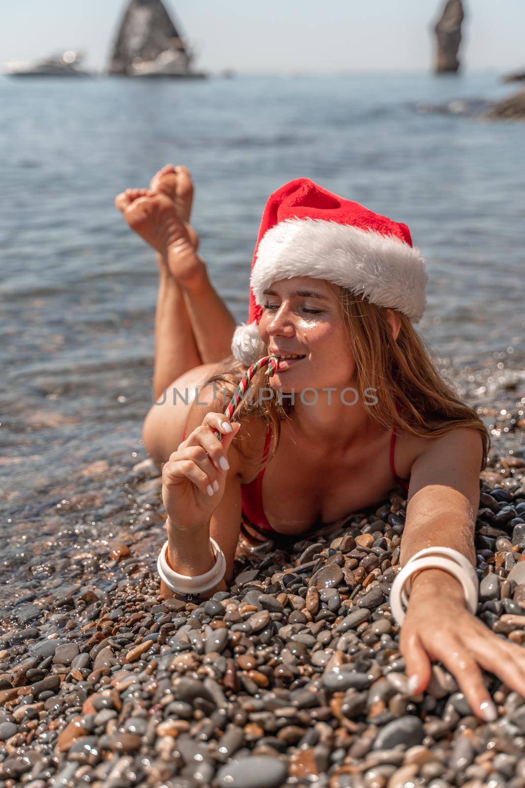 Portrait of attractive girl in red santa hat celebrating christmas holidays at sea, exotic travel and vacation concept by Matiunina