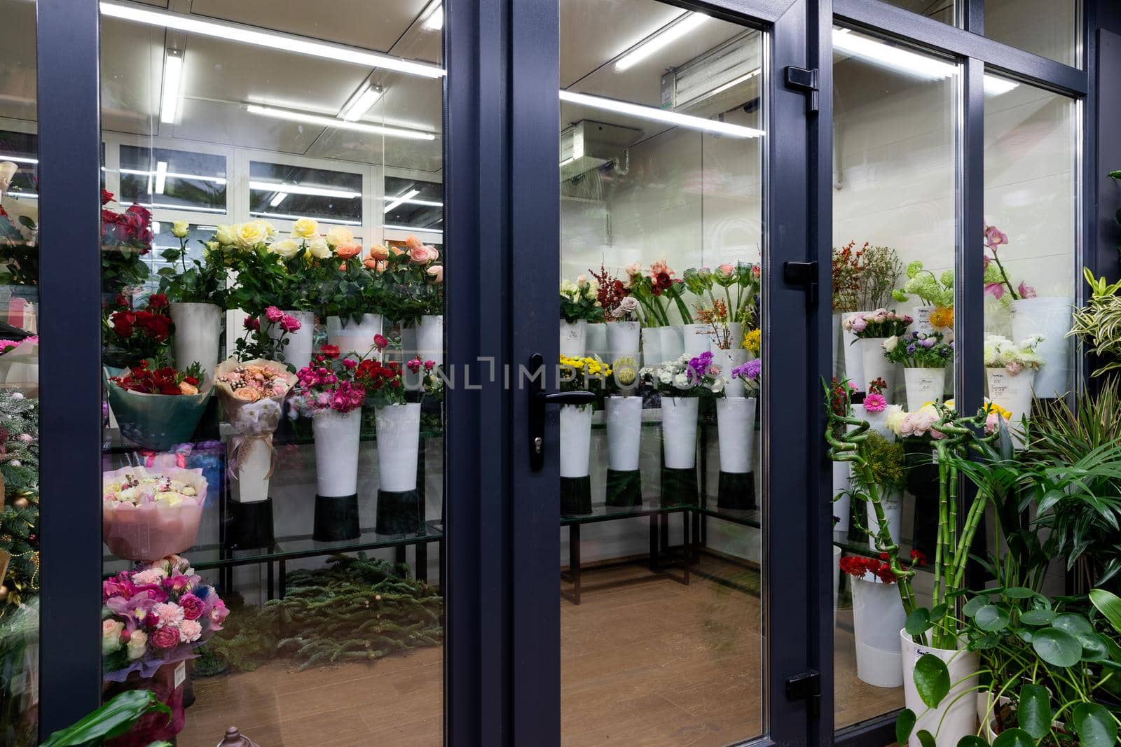 showcase of a florist shop selling natural flowers with bouquets in the refrigerator In vases