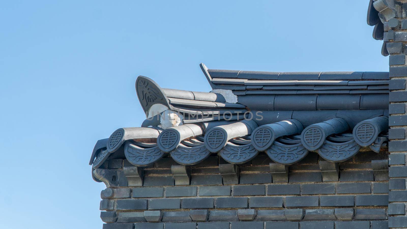 Part of the roof in the oriental style, tiles and brickwork, background by voktybre