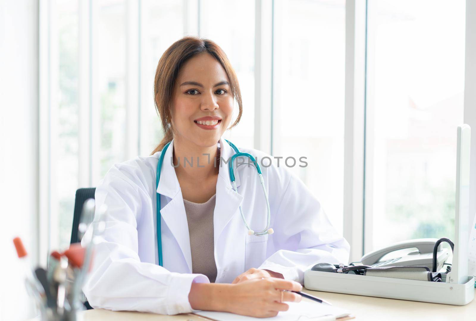 A female doctor works in an office at a hospital or clinic.  Smile and confident woman