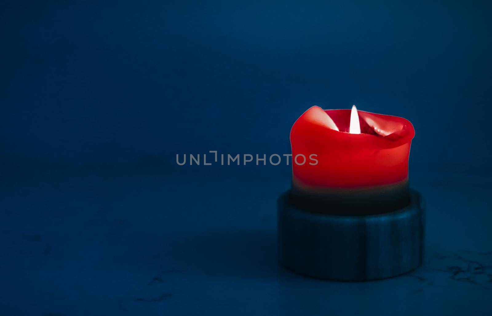 Happy holidays, greeting card backdrop and winter season concept - Red holiday candle on blue background, luxury branding design and decoration for Christmas, New Years Eve and Valentines Day