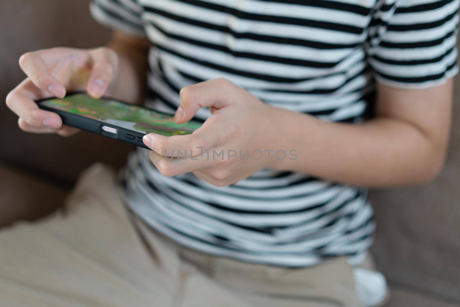 Hand kid holding smartphone for playing games by Buttus_casso