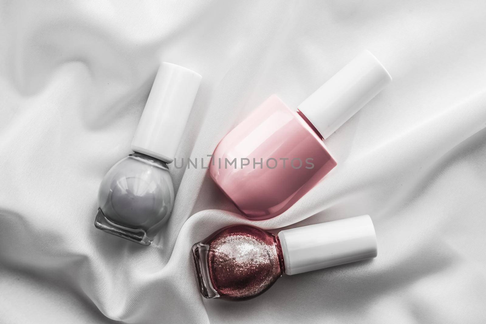 Cosmetic branding, salon and glamour concept - Nail polish bottles on silk background, french manicure products and nailpolish make-up cosmetics for luxury beauty brand and holiday flatlay art design