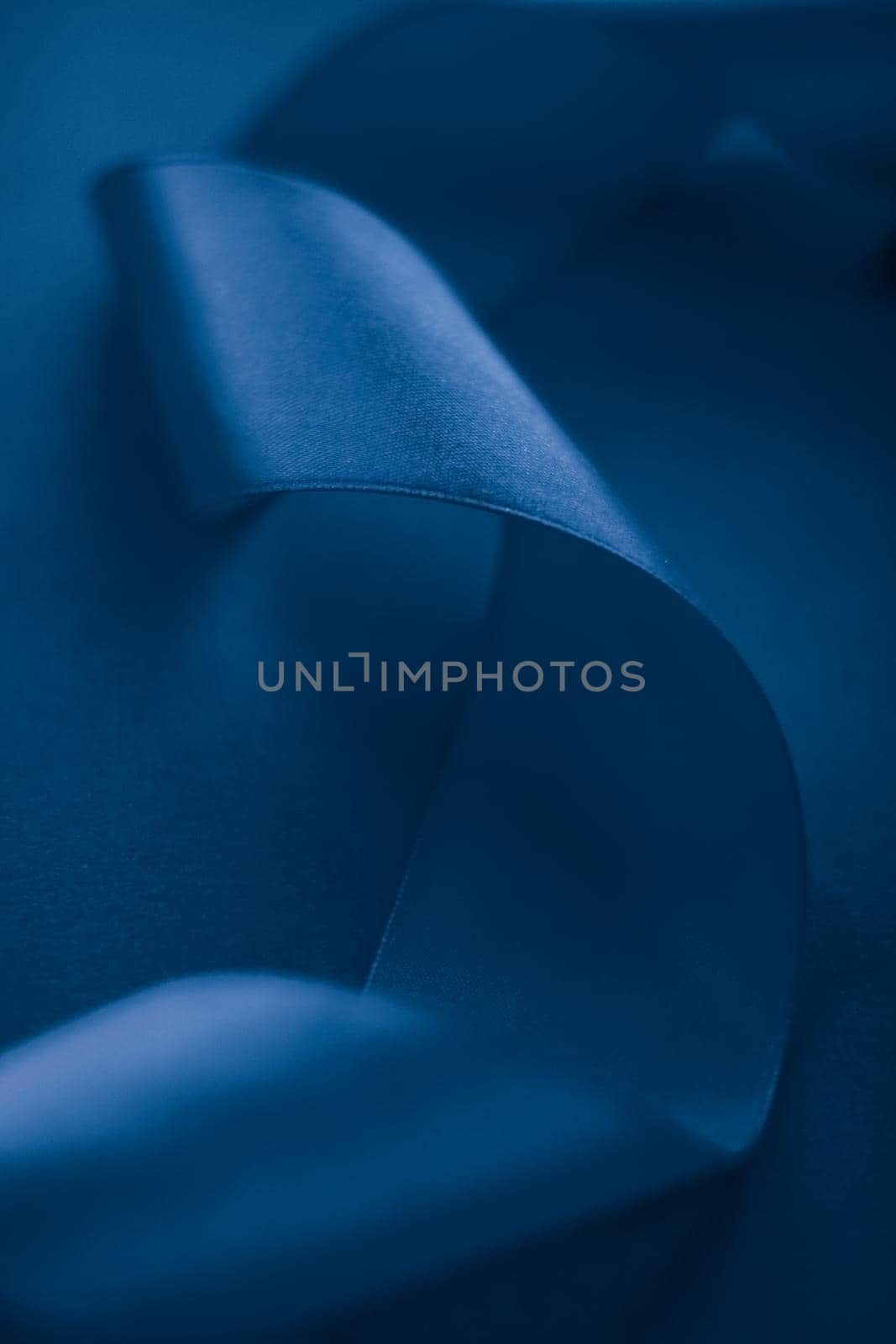 Branding, holidays and luxe brands concept - Abstract silk ribbon on royal blue background, exclusive luxury brand design for holiday sale product promotion and glamour art invitation card backdrop