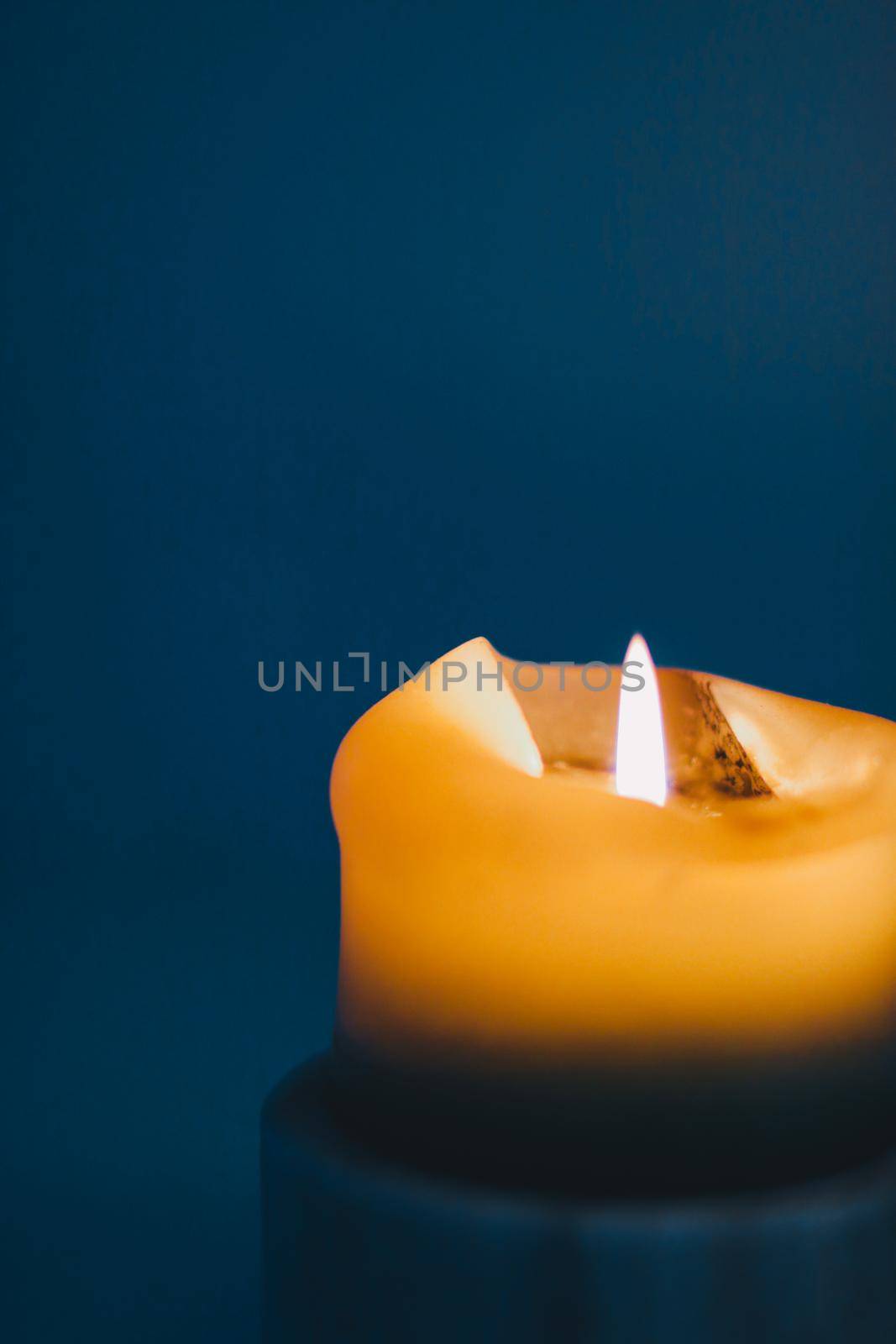 Happy holidays, greeting card backdrop and winter season concept - Yellow holiday candle on blue background, luxury branding design and decoration for Christmas, New Years Eve and Valentines Day