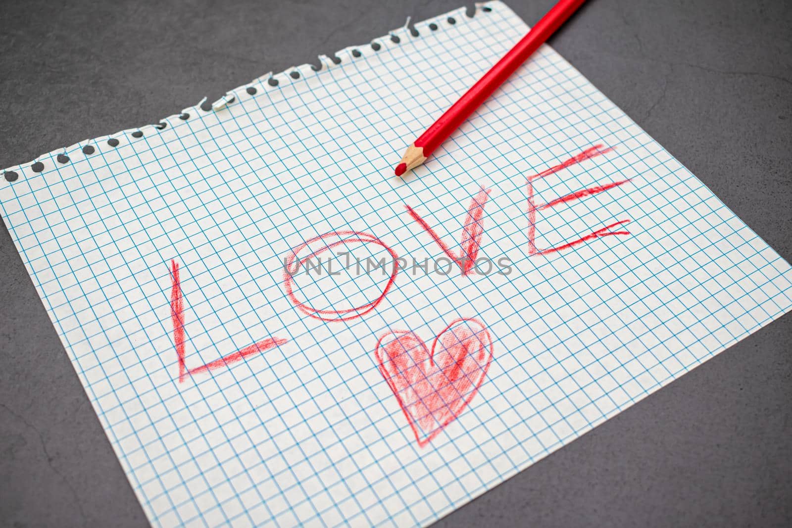 A torn piece of paper on which a declaration of love is written in pencil