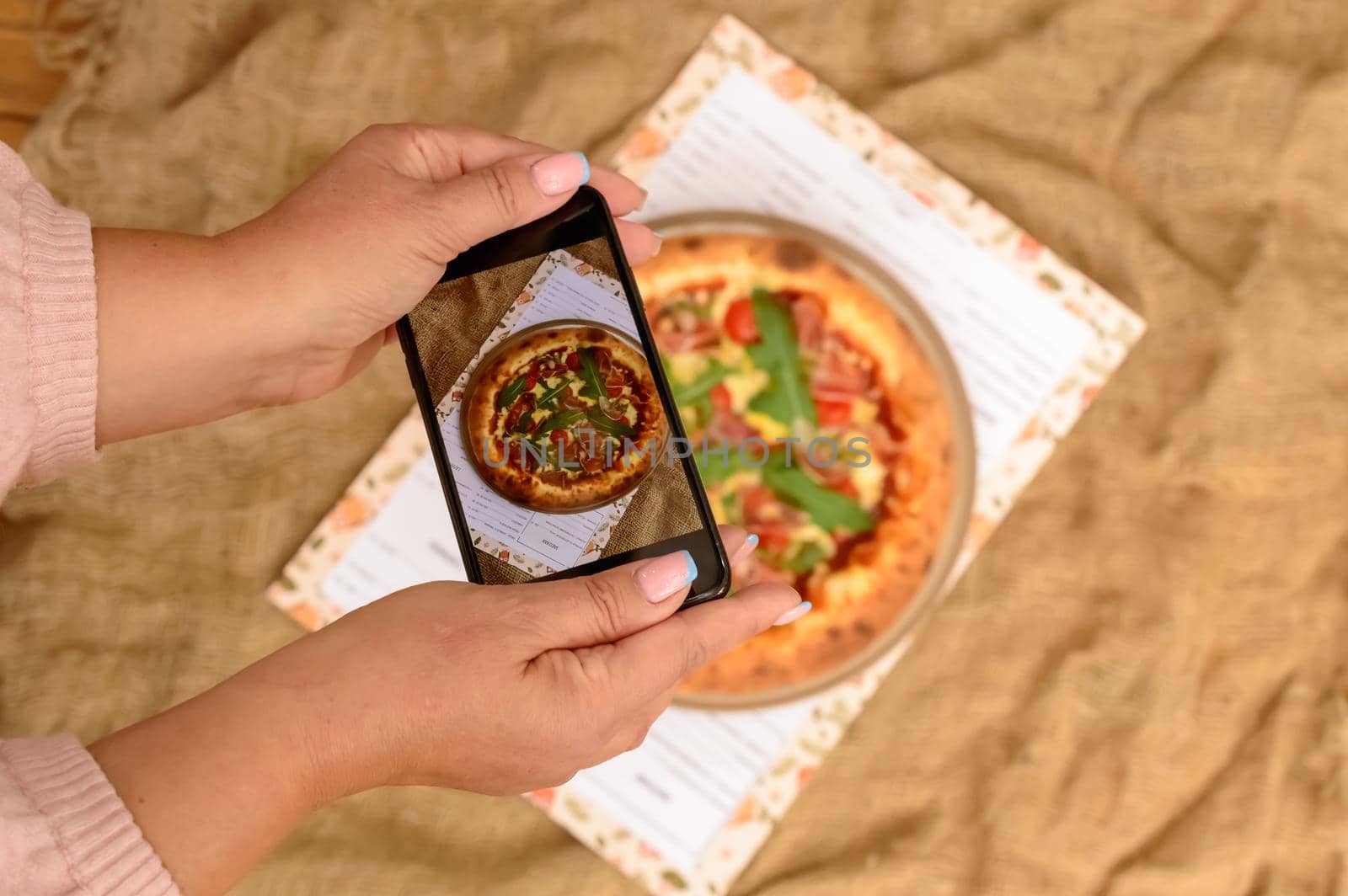 Photographing food. Hands taking picture of delicious pizza with smartphone. High quality photo