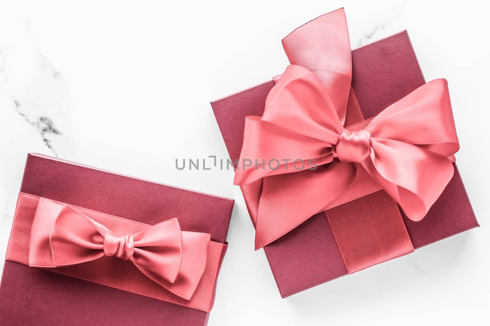 Birthday, wedding and girly branding concept - Coral gift box with silk bow on marble background, girl baby shower present and glamour fashion gift for luxury beauty brand, holiday flatlay art design