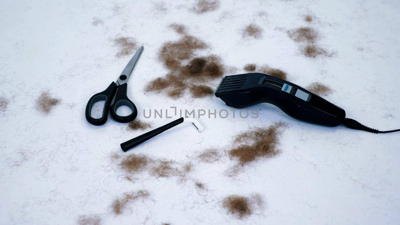 close up of Barber tools and a lot of cut hair from the body, on white background. tools for depilation, hair removal, Men's haircut. clipper, electric razor, trimer, scissors. High quality photo