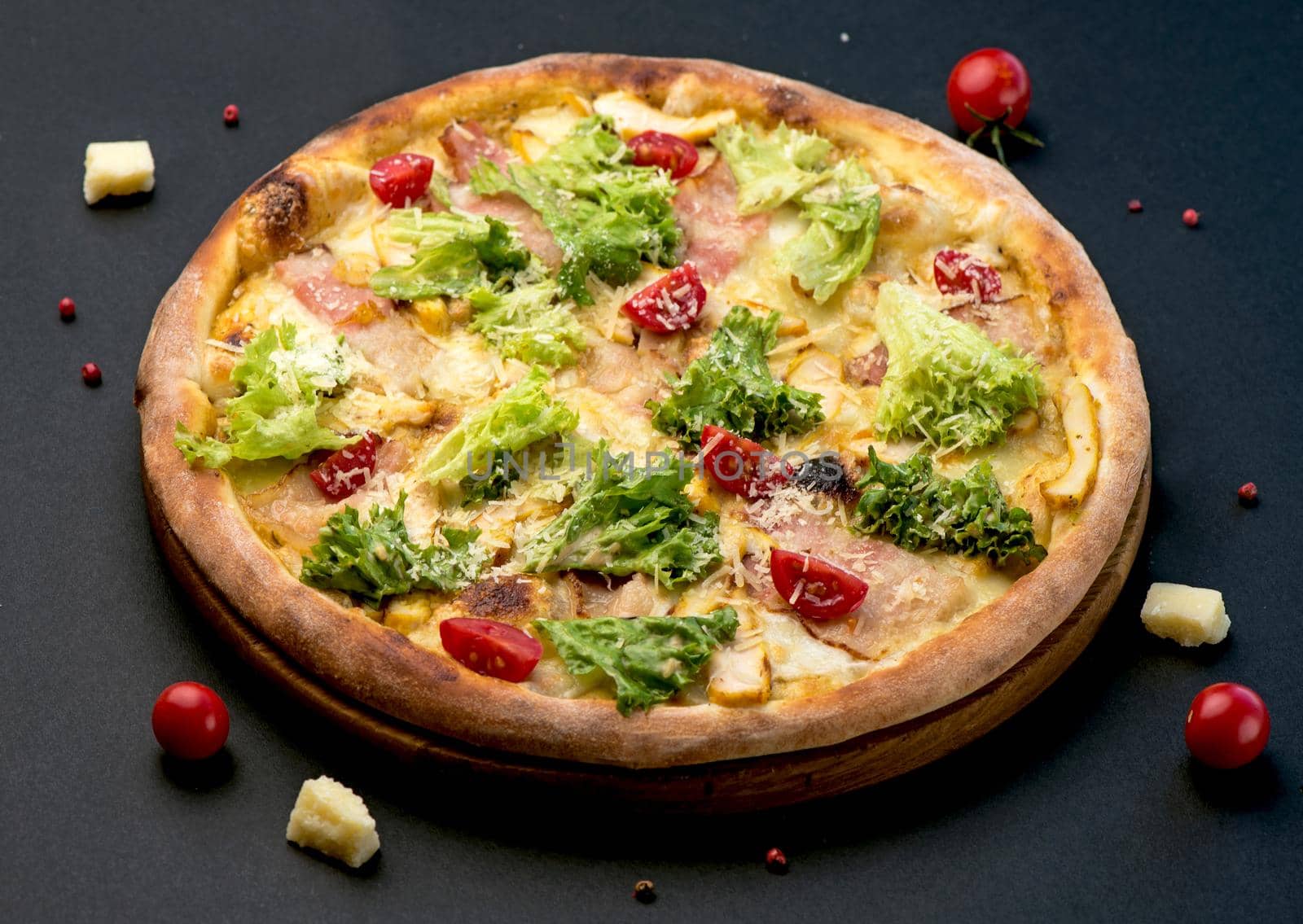 Traditional Italian pizza, vegetables, ingredients on a dark background. Pizza is cooked in the oven. by aprilphoto