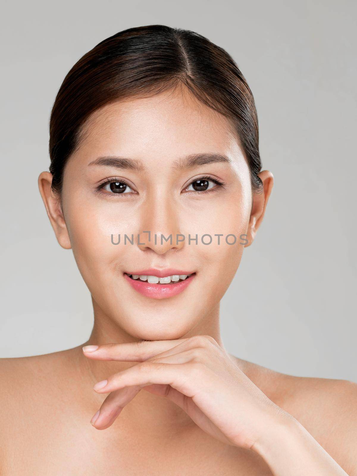 Closeup ardent young woman with healthy clear skin and soft makeup looking at camera and posing beauty gesture. Cosmetology skincare and beauty concept.