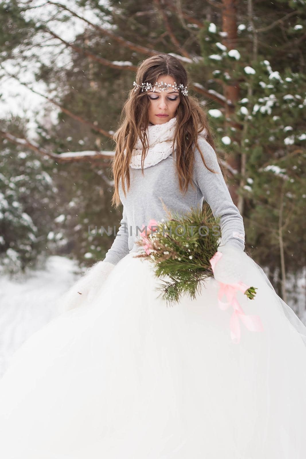 Beautiful bride in a white dress with a bouquet in a snow-covered winter forest. Portrait of the bride in nature by Annu1tochka