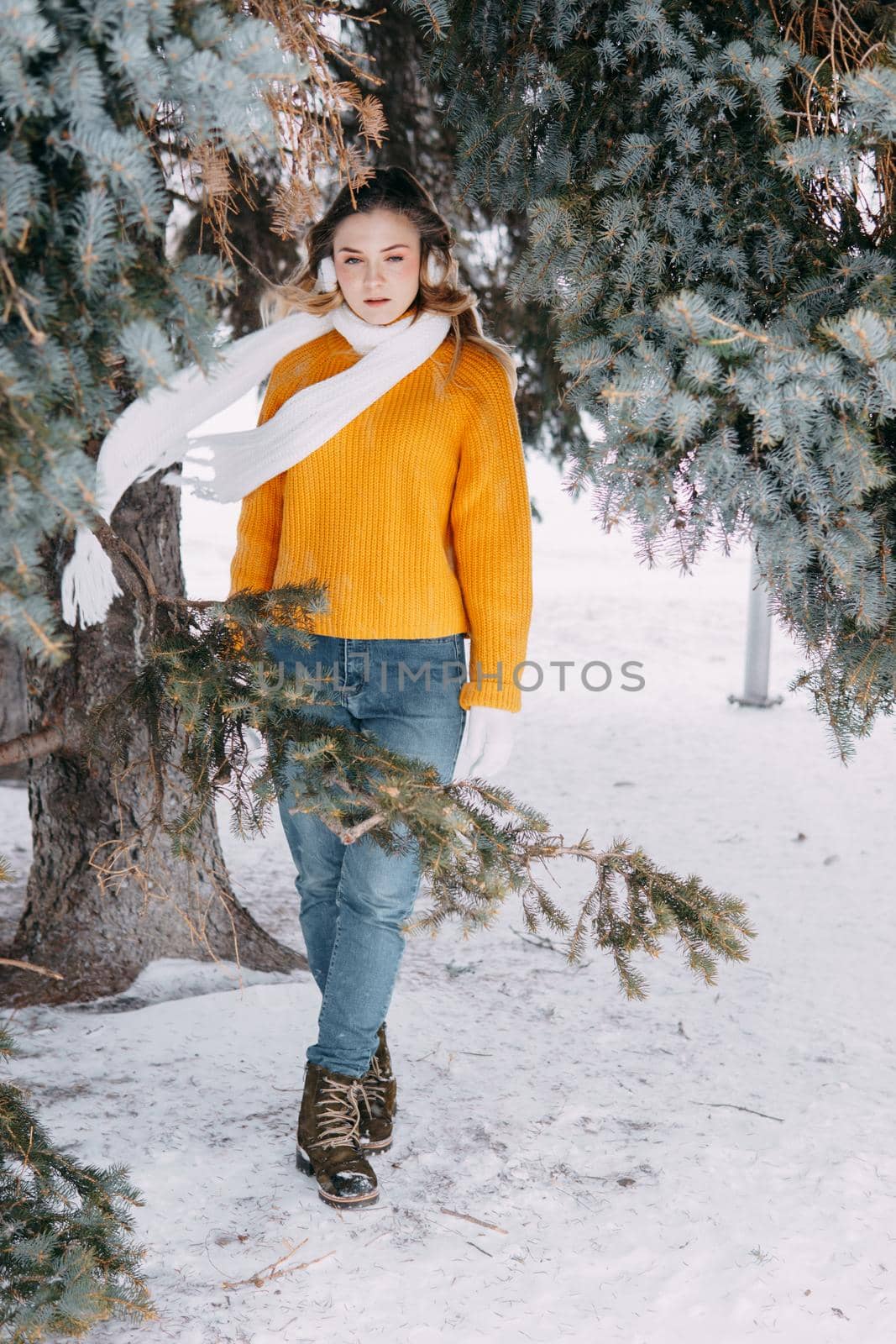 Teen blonde in a yellow sweater outside in winter. A teenage girl on a walk in winter clothes in a snowy forest by Annu1tochka