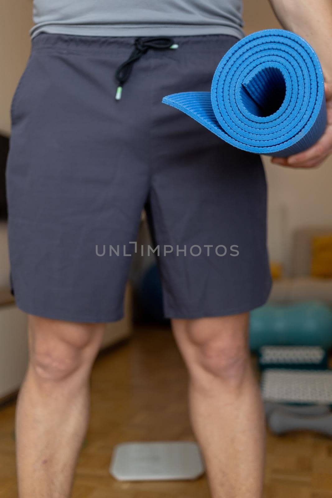 man in shorts holding yoga mat close up. High quality photo