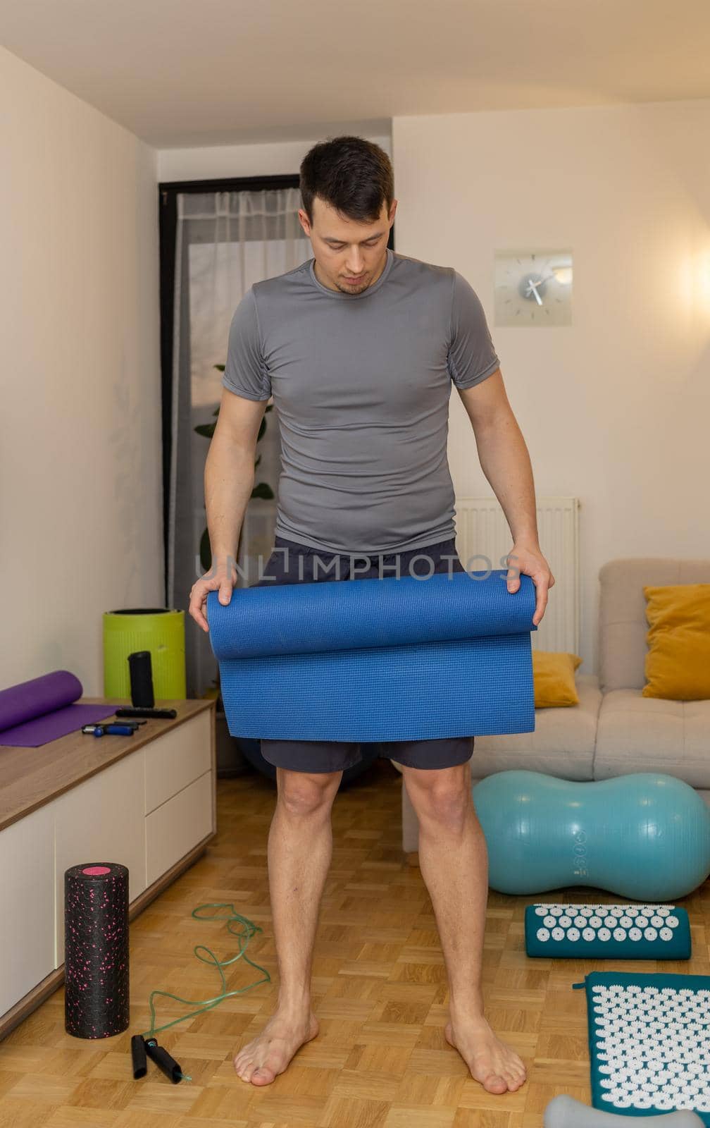 young man in headphones meditating on couch by Chechotkin