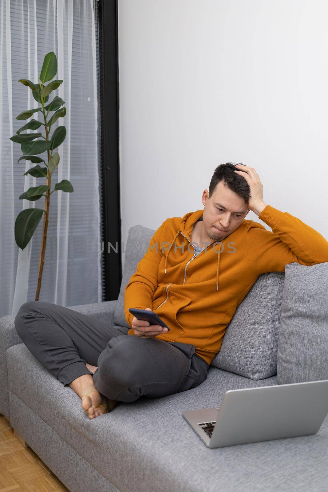 young man watching at mobile phone playing game by Chechotkin