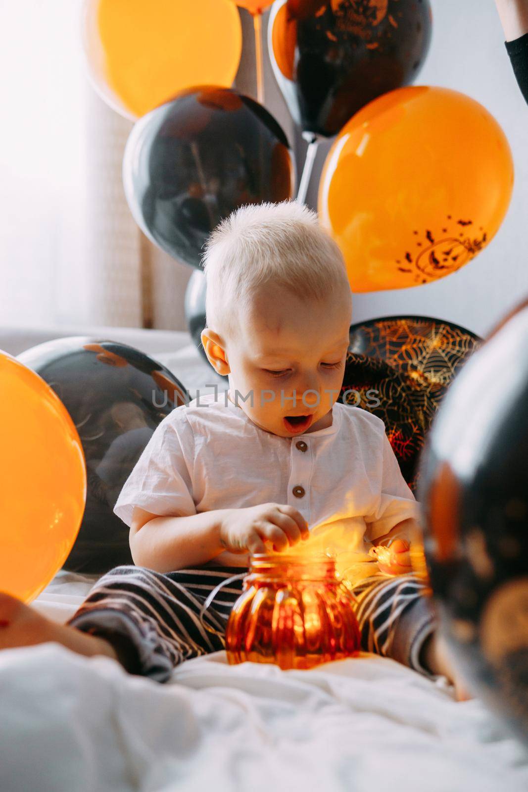 Children's Halloween - a boy in a carnival costume with orange and black balloons at home. Ready to celebrate Halloween by Annu1tochka