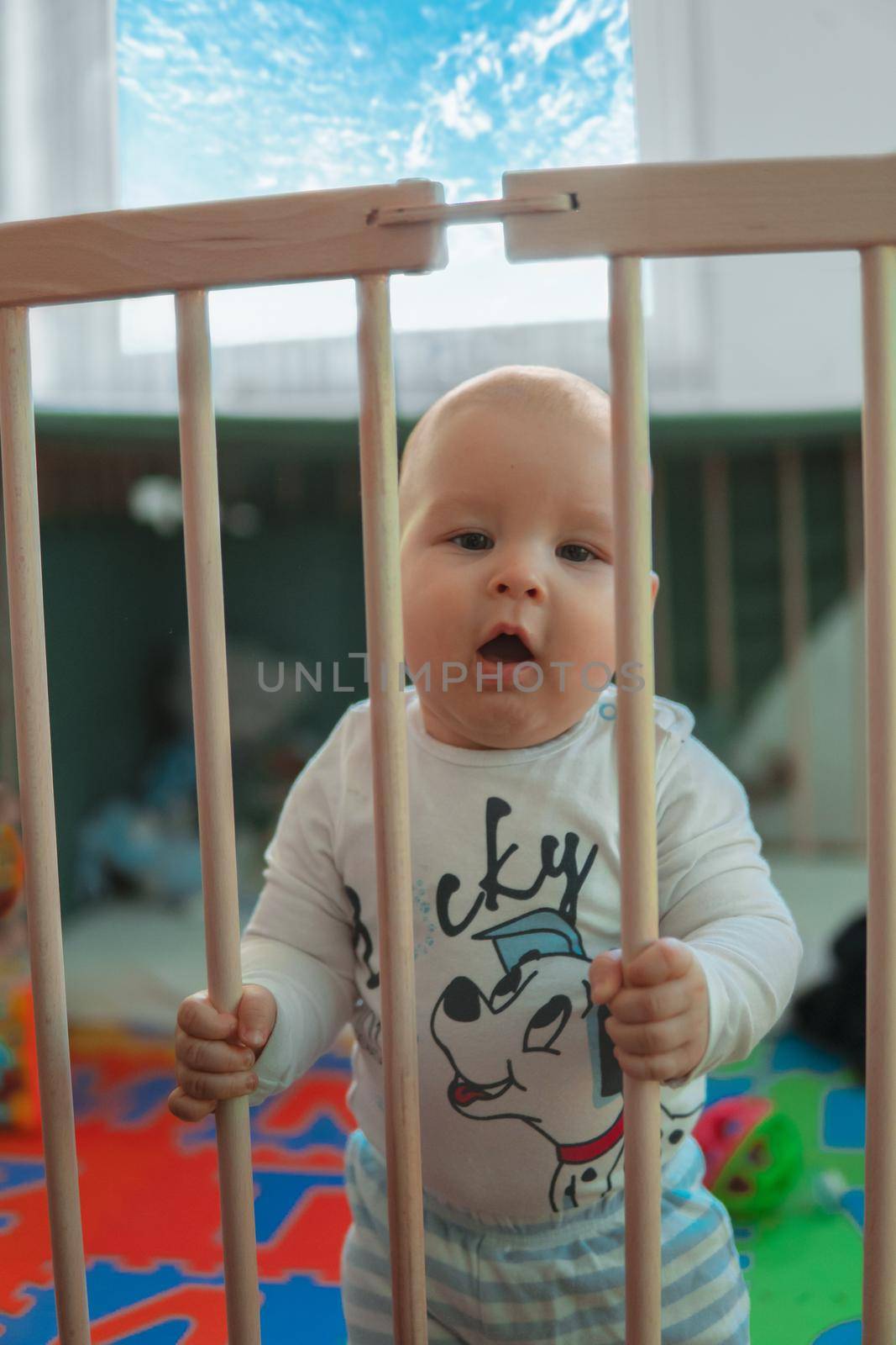baby boys trying to stand up in his crib. High quality photo