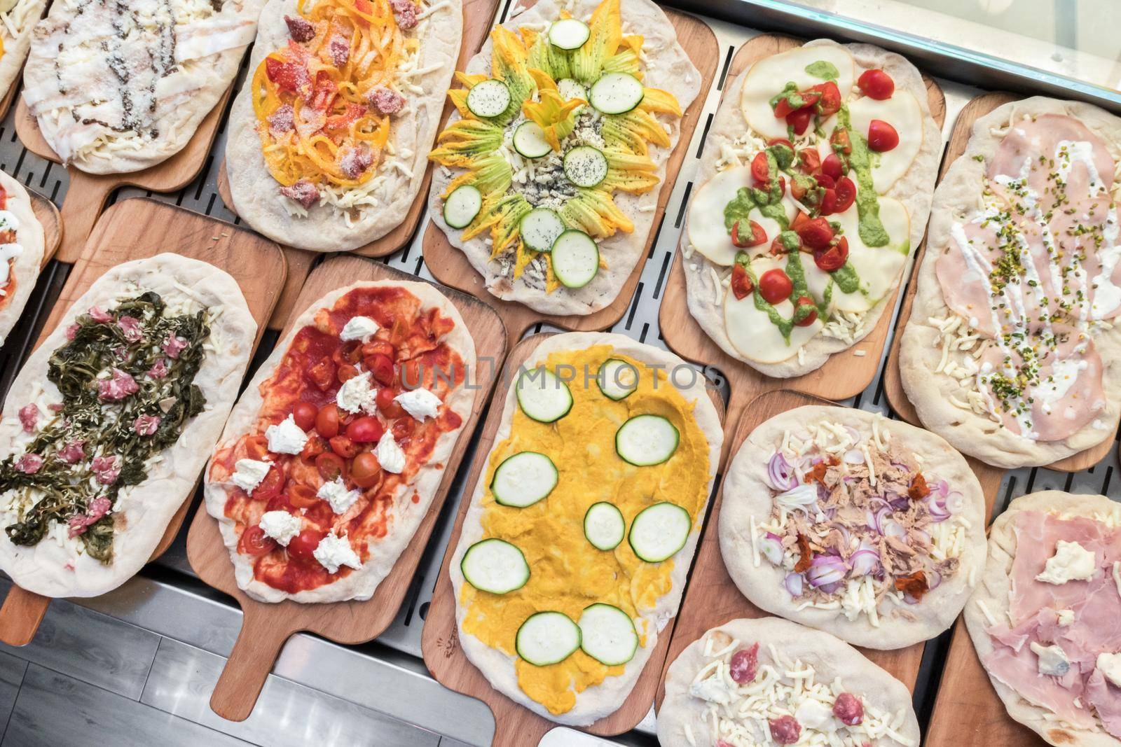 Variety of raw pizzas to bake. Restaurant. Pizzeria. Italian food.