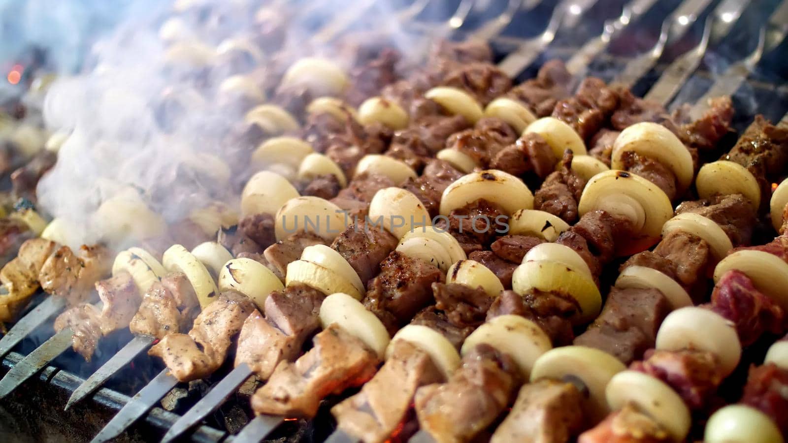 shish kebab from pork, on skewers, fried on coals. close up. Grill on charcoal and flame, picnic, street food. High quality photo