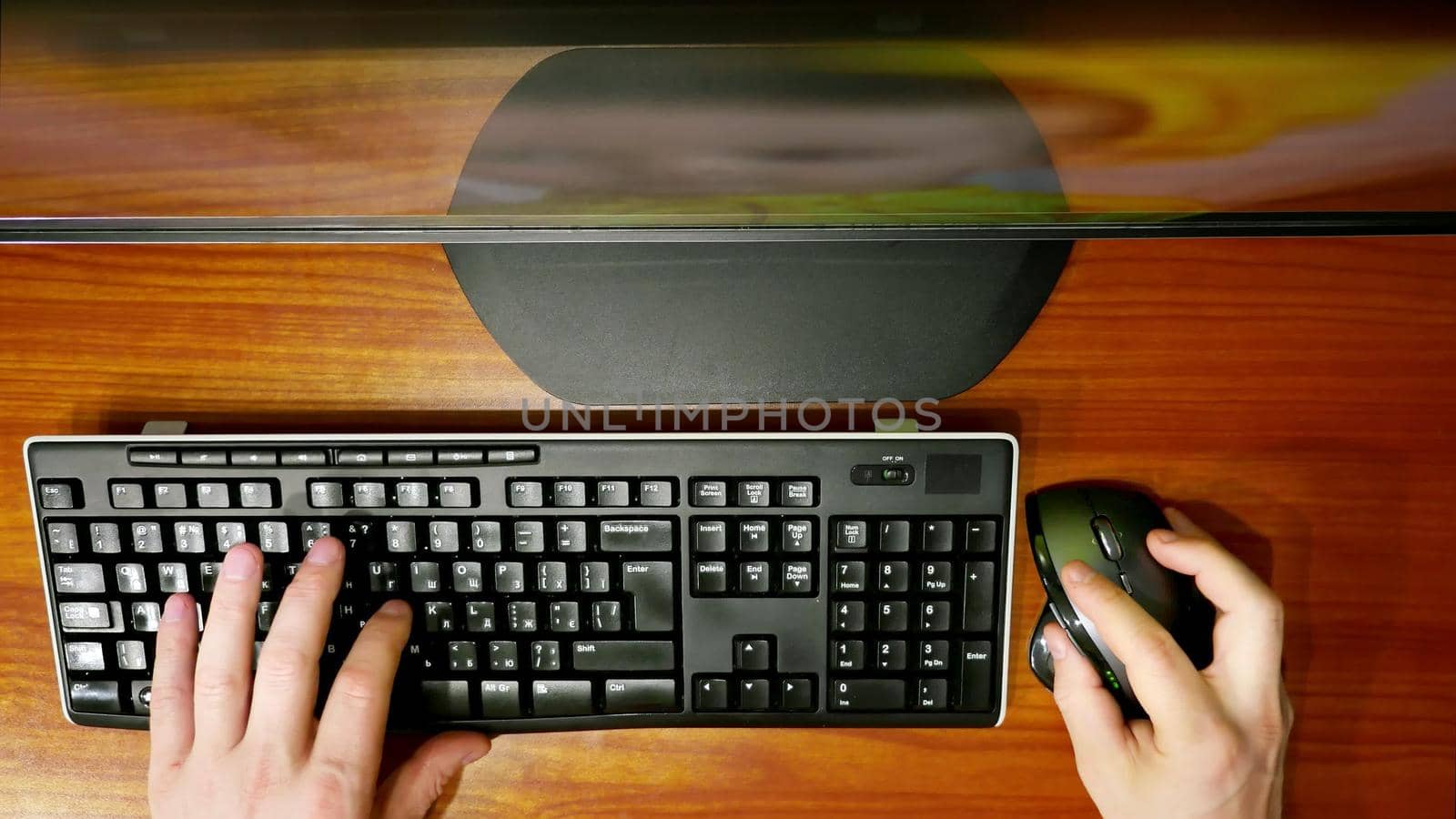 timlamps, close-up, view from the top, men's hands typing on computer keyboard with a computer mouse, in front of the monitor. Businessman working, Blogger, journalist writing. High quality photo