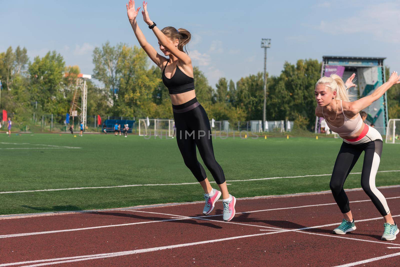 Two athlete young woman runnner are training at the stadium outdoors