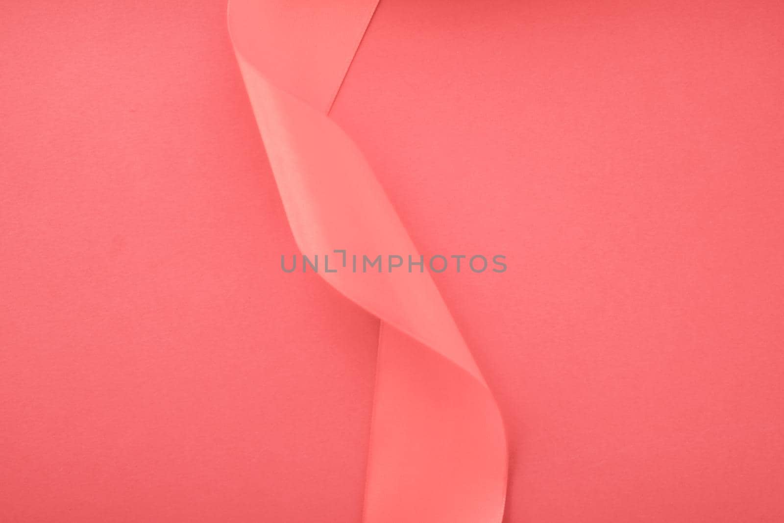 Branding, holidays and luxe brands concept - Abstract curly silk ribbon on coral background, exclusive luxury brand design for holiday sale product promotion and glamour art invitation card backdrop