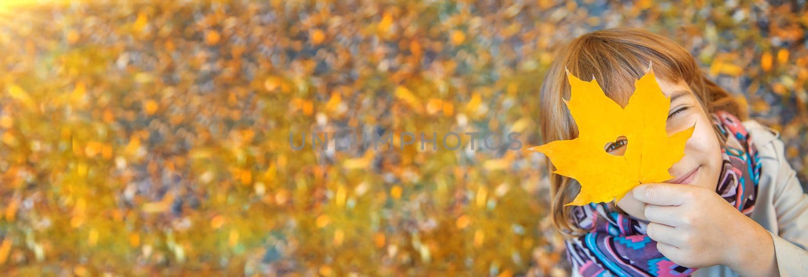 Children in the park with autumn leaves. Selective focus. by yanadjana