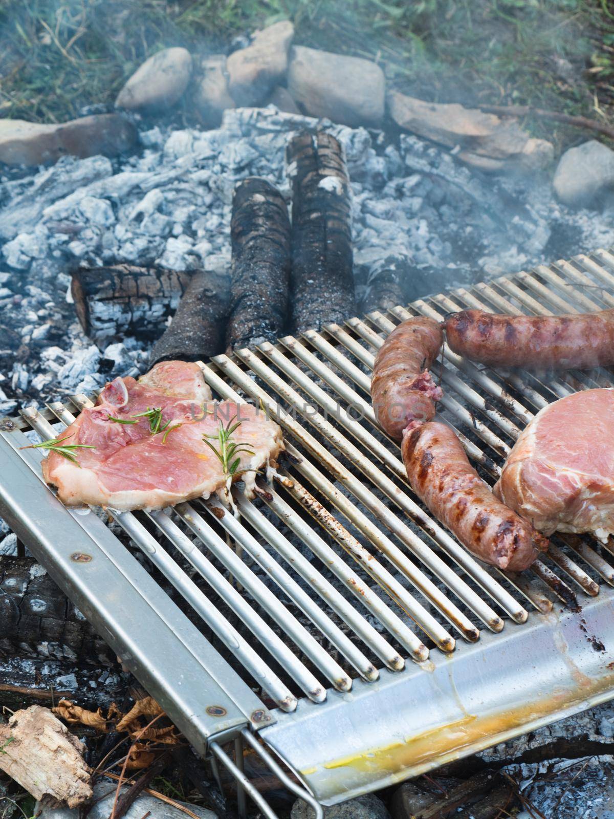 cooking pork meat in the grill outdoors with charcoal