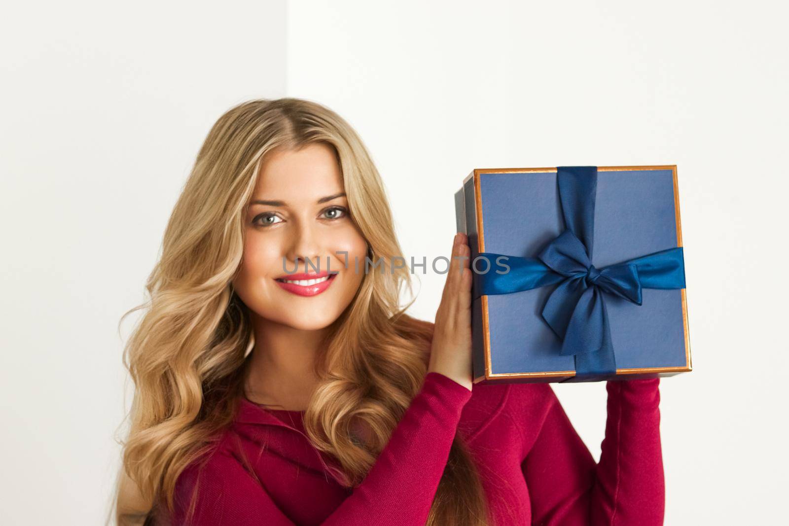 Happy woman holding a gift for birthday, anniversary, wedding, Valentines day or Christmas, luxury holiday present or beauty box subscription delivery by Anneleven